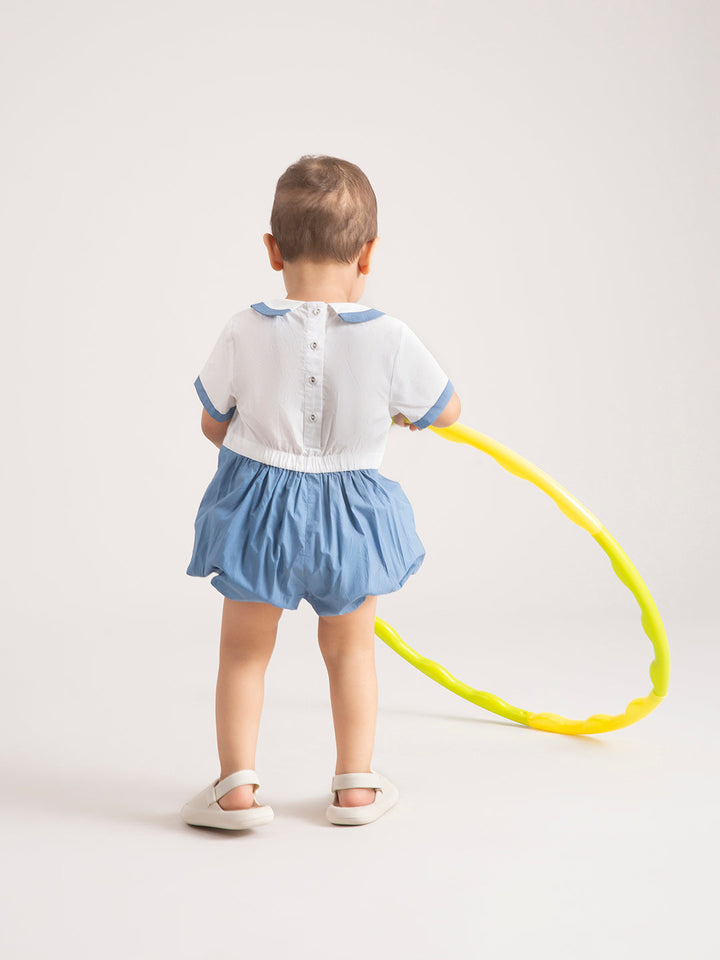 Newborn Baby  Dark Blue Organic Cotton One-Piece playing with hula hoop